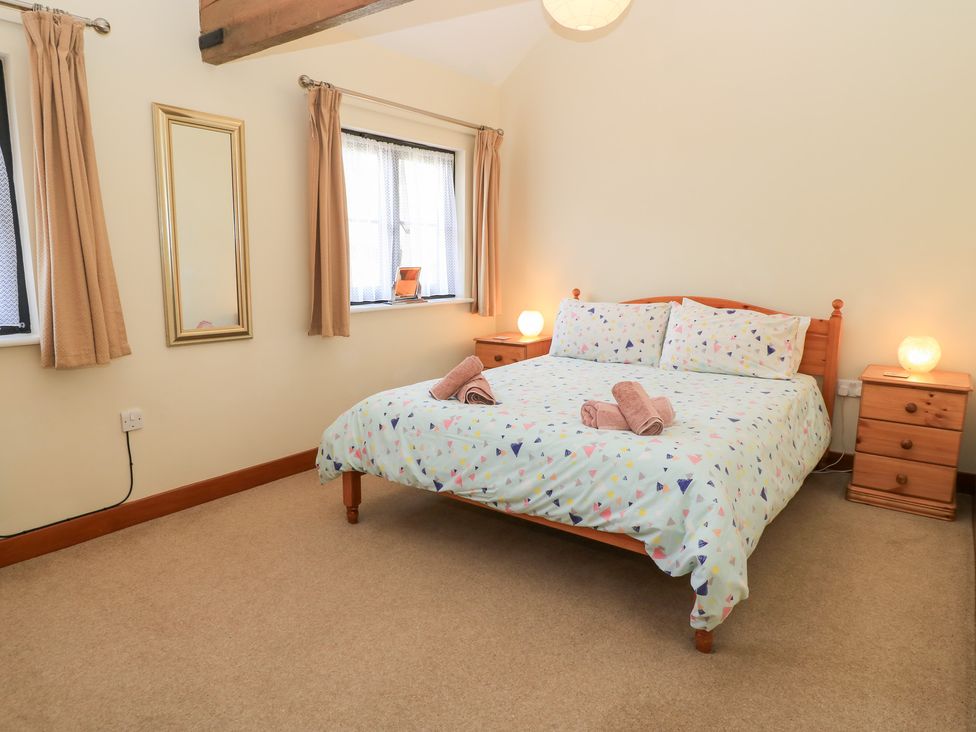 A bedroom with a bed and bedside tables at Corner Barn Winterborne Stickland