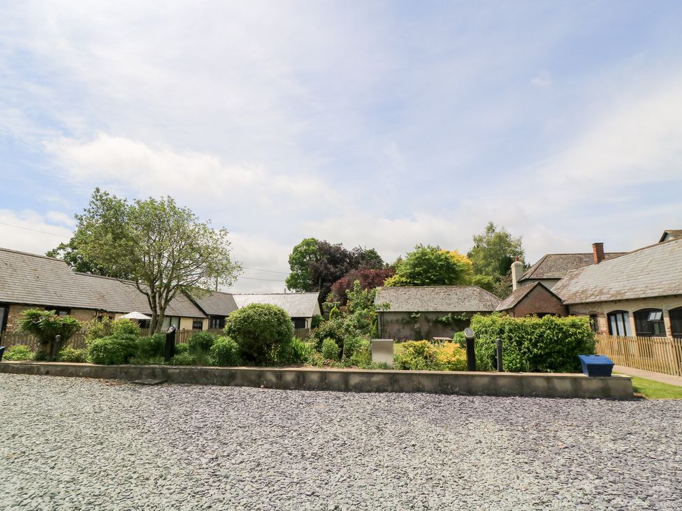 An outdoor area with buildings and greenery at Corner Barn Winterborne Stickland