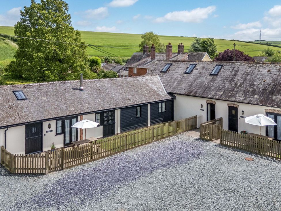 An outdoor area with buildings and a fence at Corner Barn Winterborne Stickland