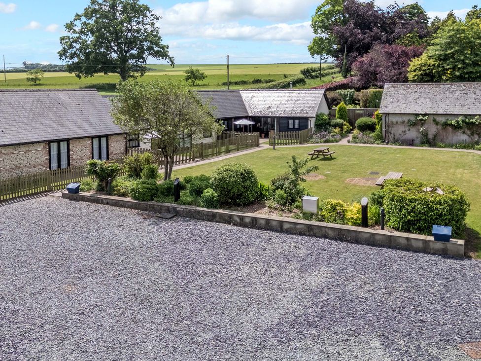 An outdoor area with buildings and a garden at Corner Barn Winterborne Stickland