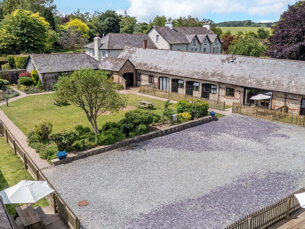 A garden with a house and seating area at Corner Barn in Winterborne Stickland