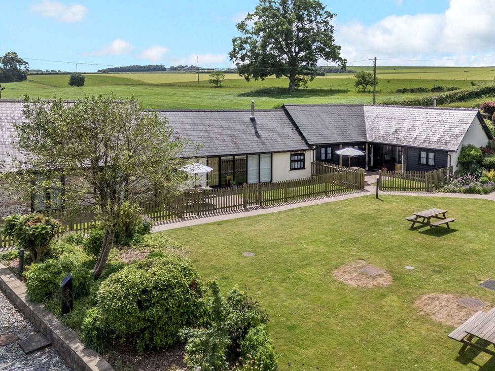 An outdoor area with a garden and seating at Corner Barn in Winterborne Stickland