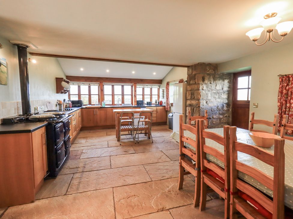 A kitchen with cabinets and a dining table at Usherwoods Dairy Tatham