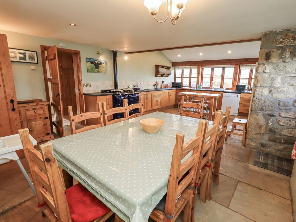 A kitchen with a dining table and wooden cabinets at Usherwoods Dairy Tatham