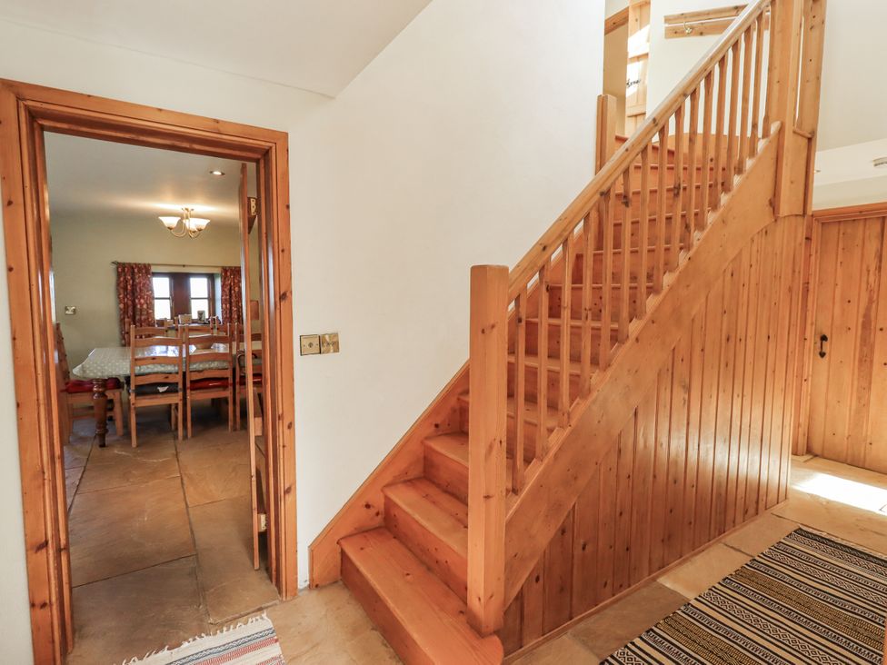 A hallway with a staircase and a view into the dining area at Usherwoods Dairy in Tatham