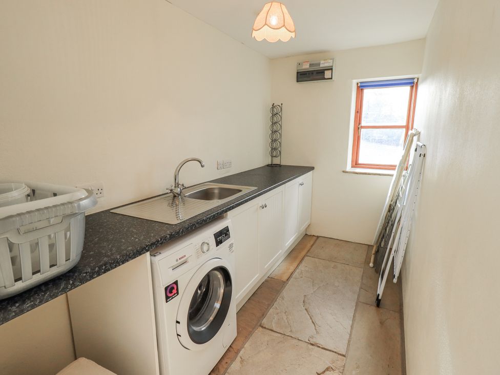 A laundry room with a washing machine and a sink at Usherwoods Dairy Tatham