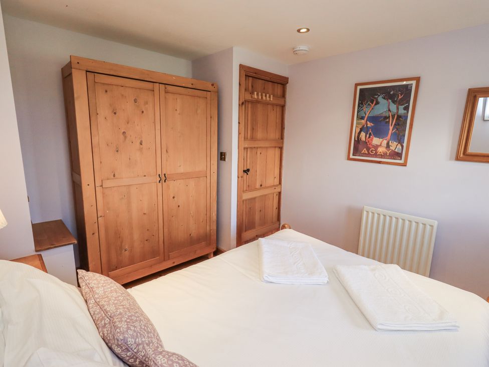 A bedroom with a bed, wardrobe, and wall art at Usherwoods Dairy in Tatham
