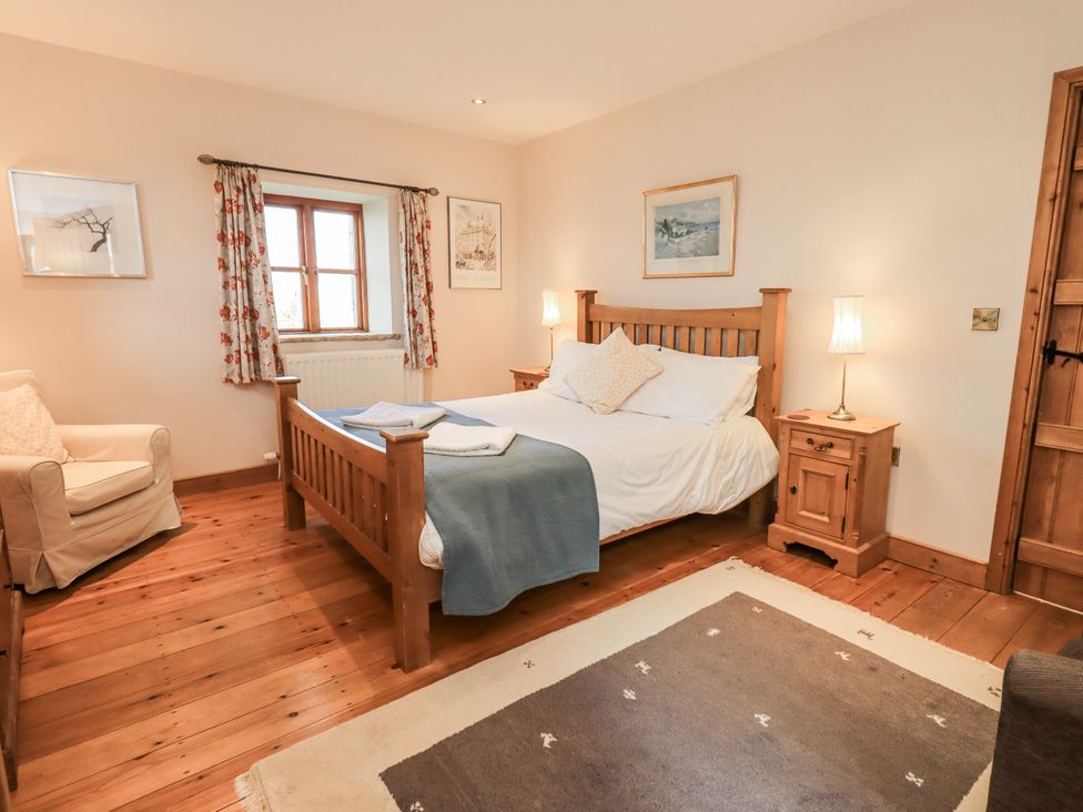A bedroom with a bed and armchair at Usherwoods Dairy in Tatham
