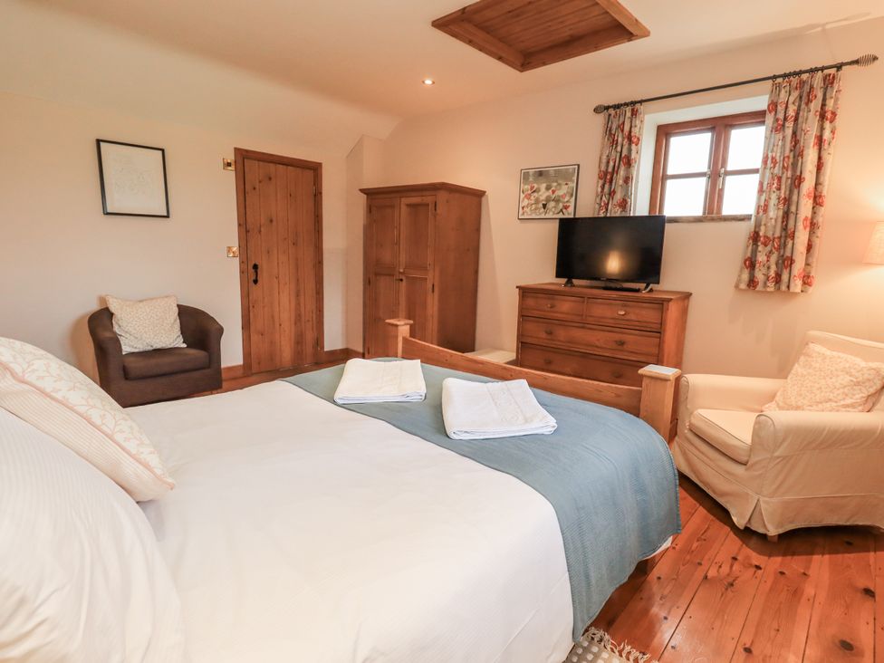 A bedroom with a bed, wardrobe, and television at Usherwoods Dairy Tatham