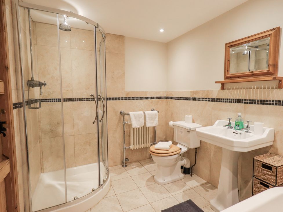 A bathroom with shower, toilet, sink, and towels at Usherwoods Dairy in Tatham
