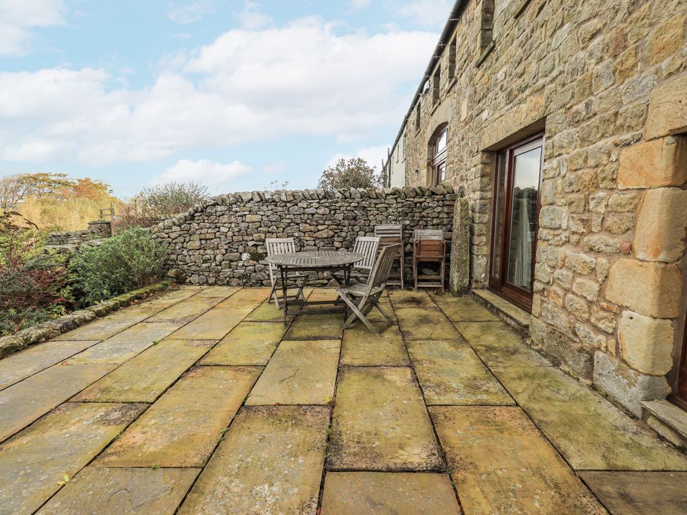 An outdoor patio with a table and chairs at Usherwoods Dairy in Tatham