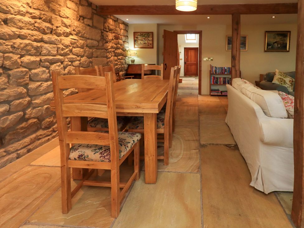 A dining room with a wooden table and chairs at Usherwoods Barn Tatham
