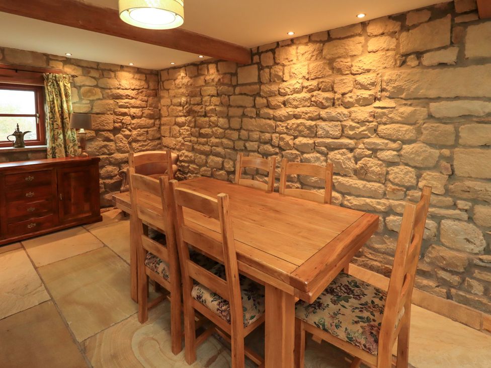 A dining room with a wooden table and chairs at Usherwoods Barn Tatham