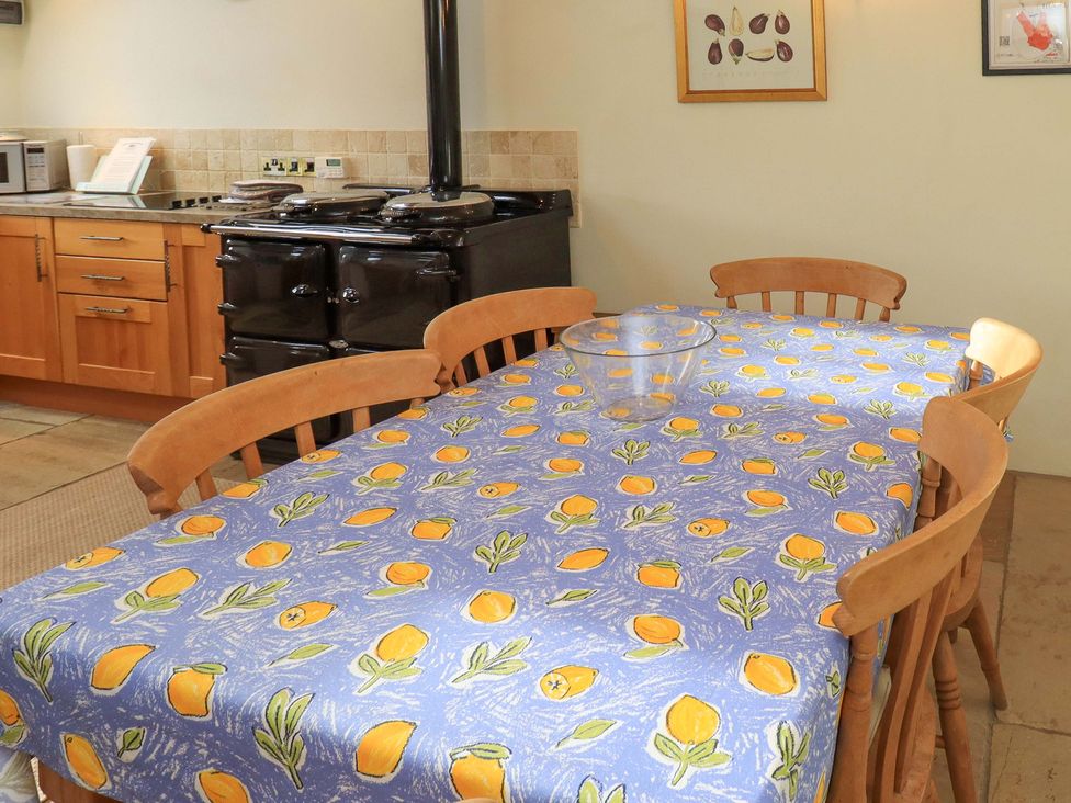 A kitchen with a wooden table and chairs at Usherwoods Barn Tatham