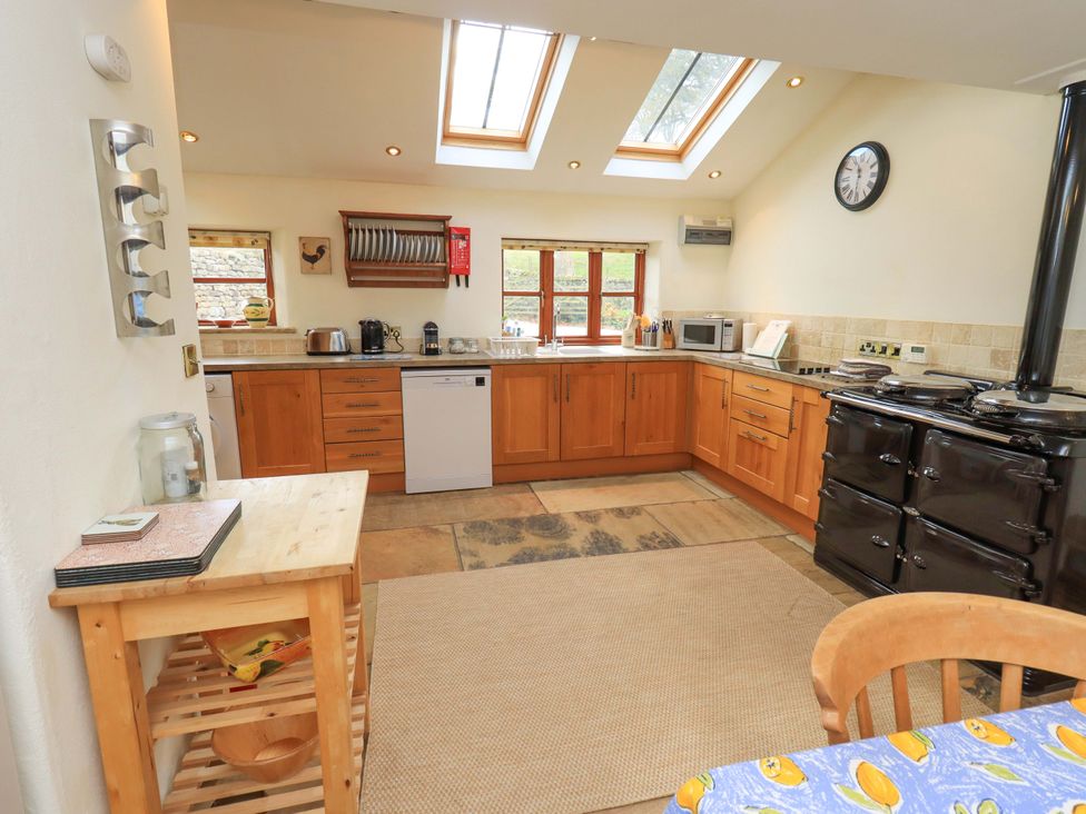 A kitchen with wooden cabinets and appliances at Usherwoods Barn Tatham