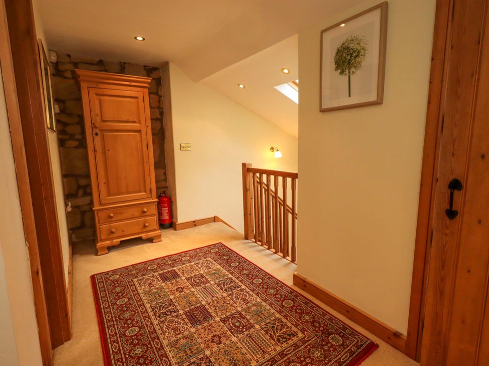 A hallway with a wardrobe and a rug at Usherwoods Barn Tatham