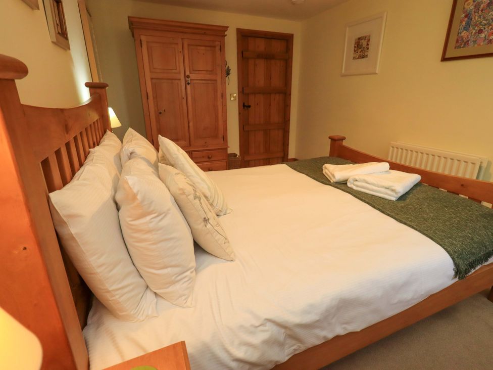 A bedroom with a bed and wardrobe at Usherwoods Barn Tatham