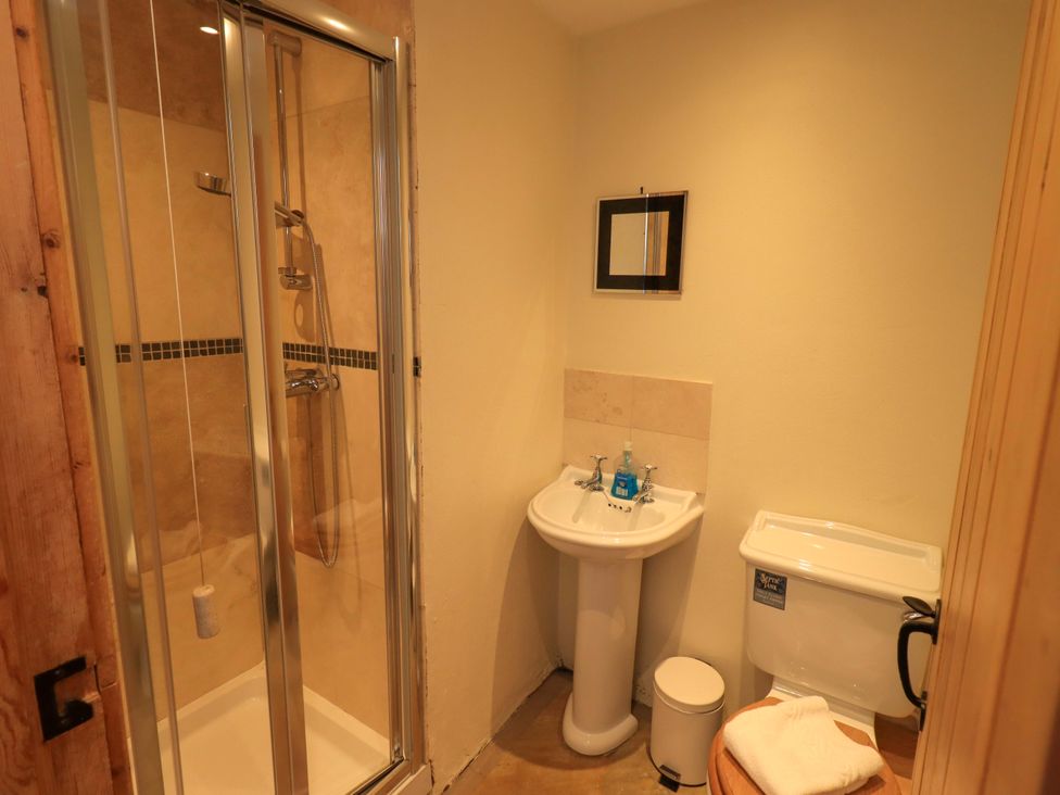 A bathroom with a shower, sink, and toilet at Usherwoods Barn in Tatham