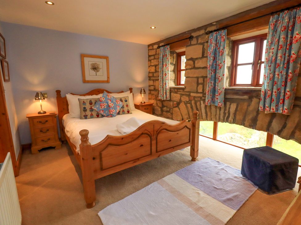 A bedroom with a bed and wooden furniture at Usherwoods Barn in Tatham