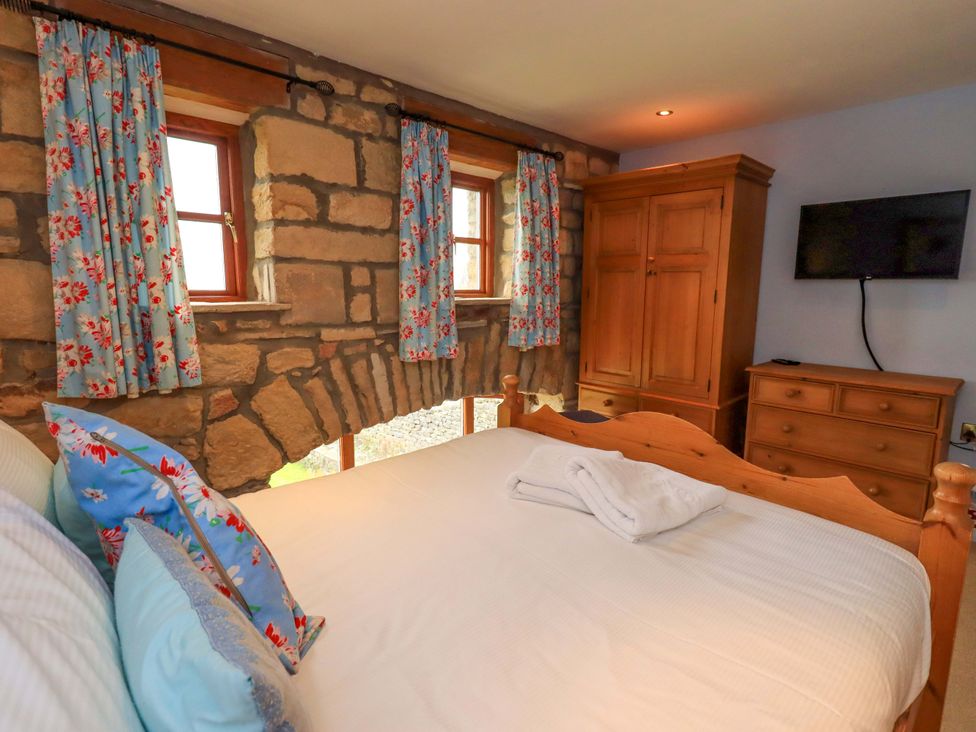 A bedroom with a bed and windows at Usherwoods Barn Tatham
