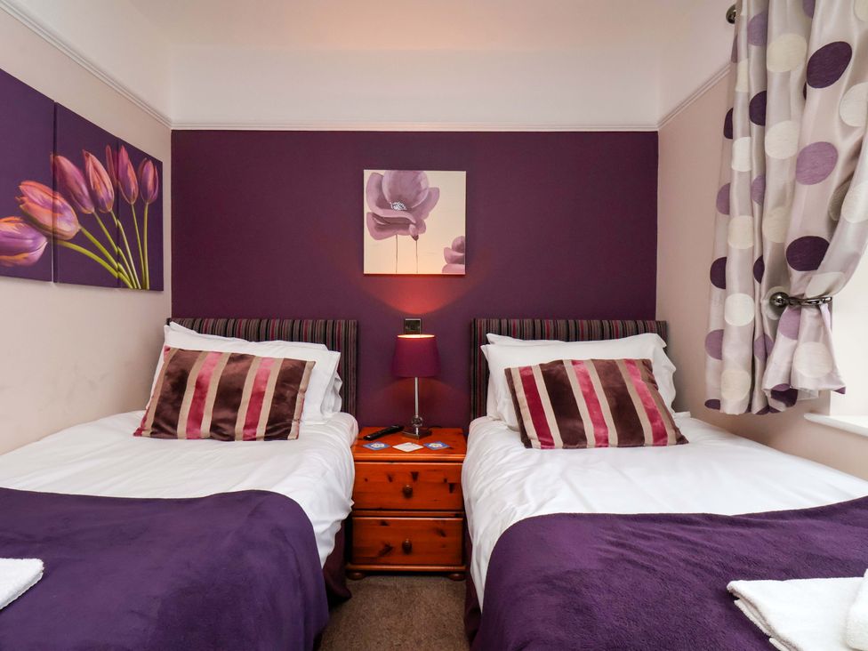 A bedroom with two single beds and wall art at Dilston House in Goathland