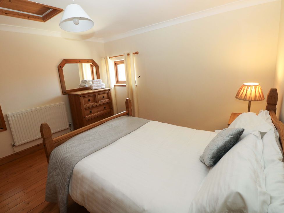 A bedroom with a bed and a chest of drawers at The Dairy in Penuel near Llanmorlais