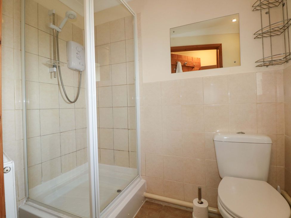 A bathroom with a shower and toilet at The Dairy in Penuel near Llanmorlais
