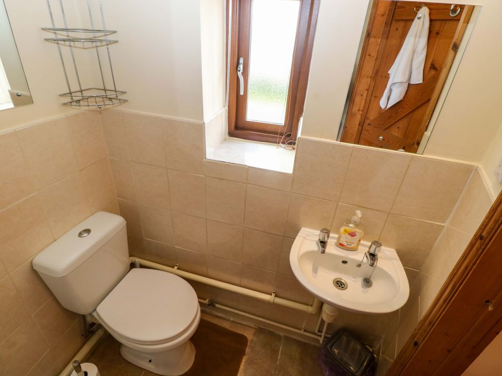 A bathroom with a toilet and sink at The Dairy in Penuel near Llanmorlais