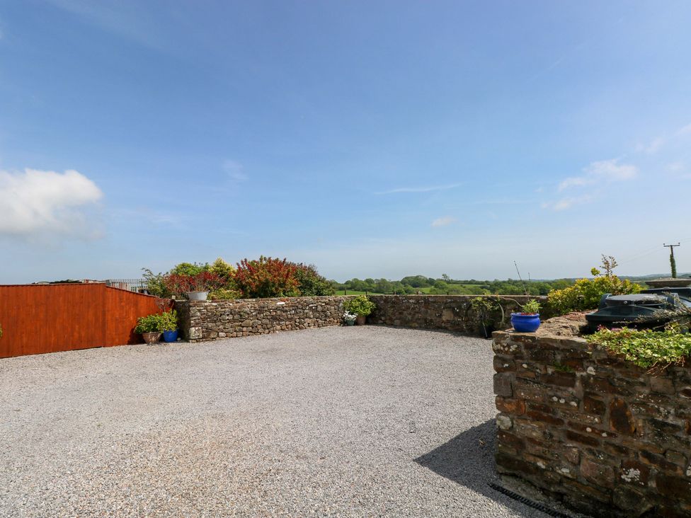 An outdoor area with gravel and stone wall at The Dairy in Penuel near Llanmorlais