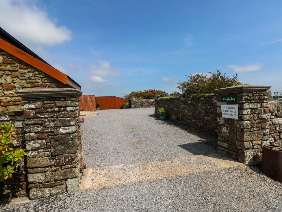 An outdoor parking area with a stone wall at The Dairy Penuel near Llanmorlais