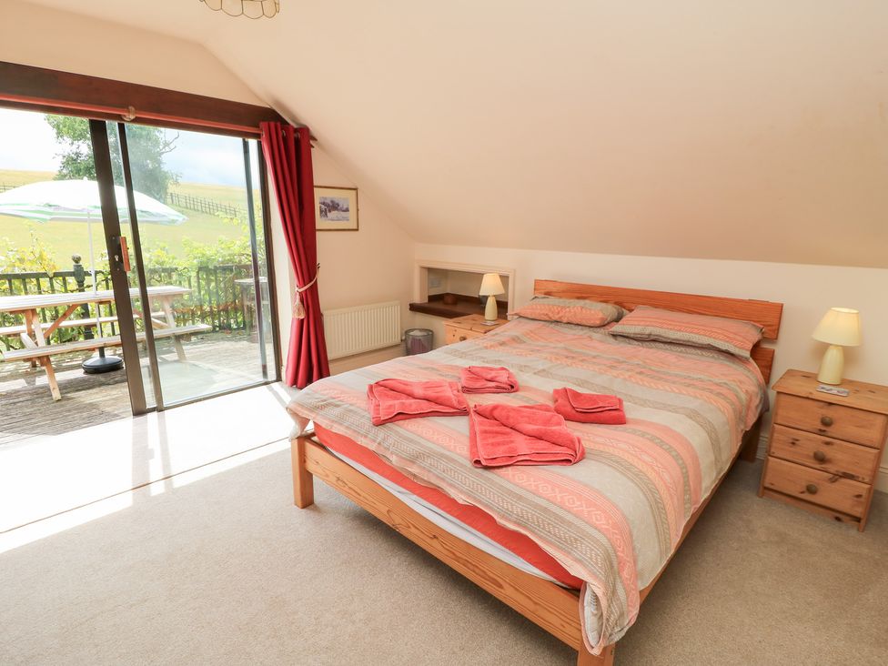 A bedroom with a bed and sliding glass door at Uplands Over Compton near Sherborne