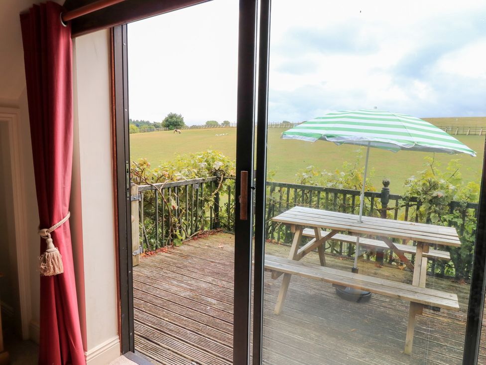 A balcony with a table and umbrella at Uplands Over Compton near Sherborne