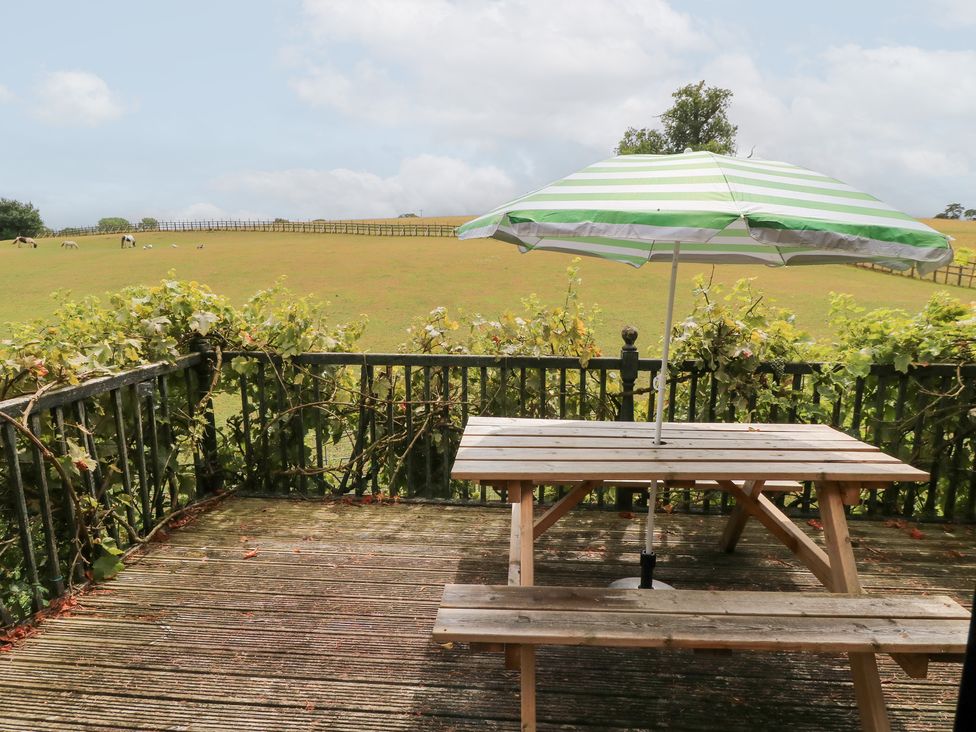 A garden area with a table and an umbrella at Uplands Over Compton near Sherborne