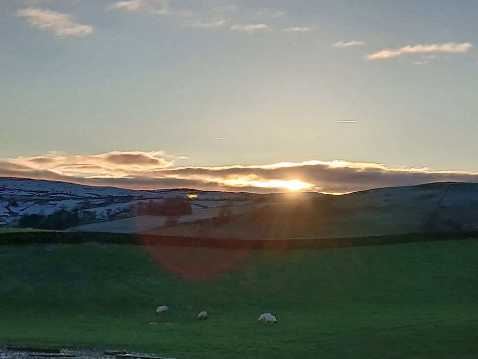 A sunset over hills with grazing sheep in Howgill near Sedbergh