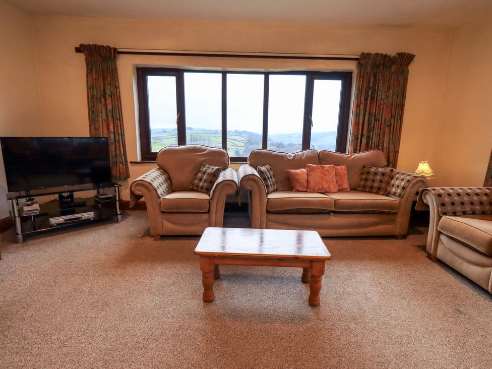 A living room with a sofa and a television at Ghyll Bank House Staveley near Windermere