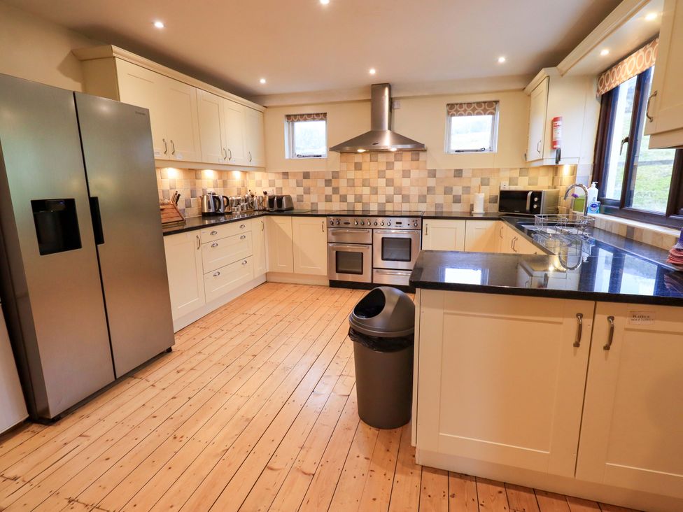A kitchen with appliances and counter space at Ghyll Bank House in Staveley near Windermere