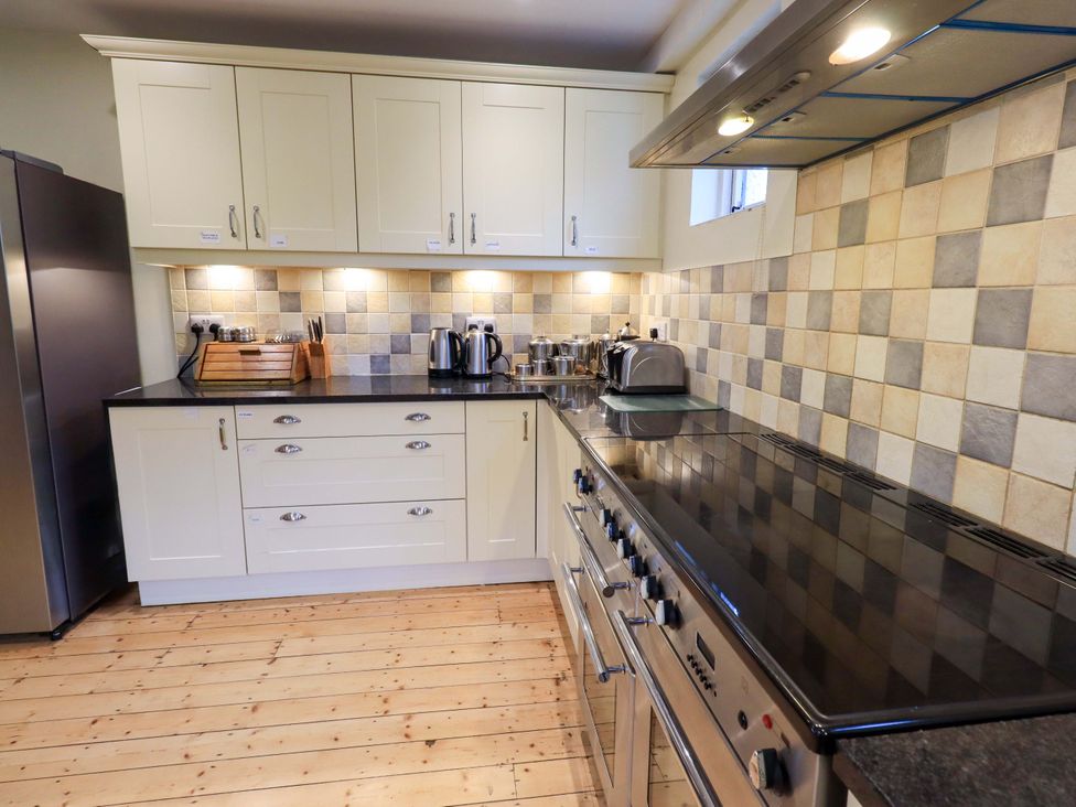 A kitchen with appliances and cabinets at Ghyll Bank House Staveley near Windermere