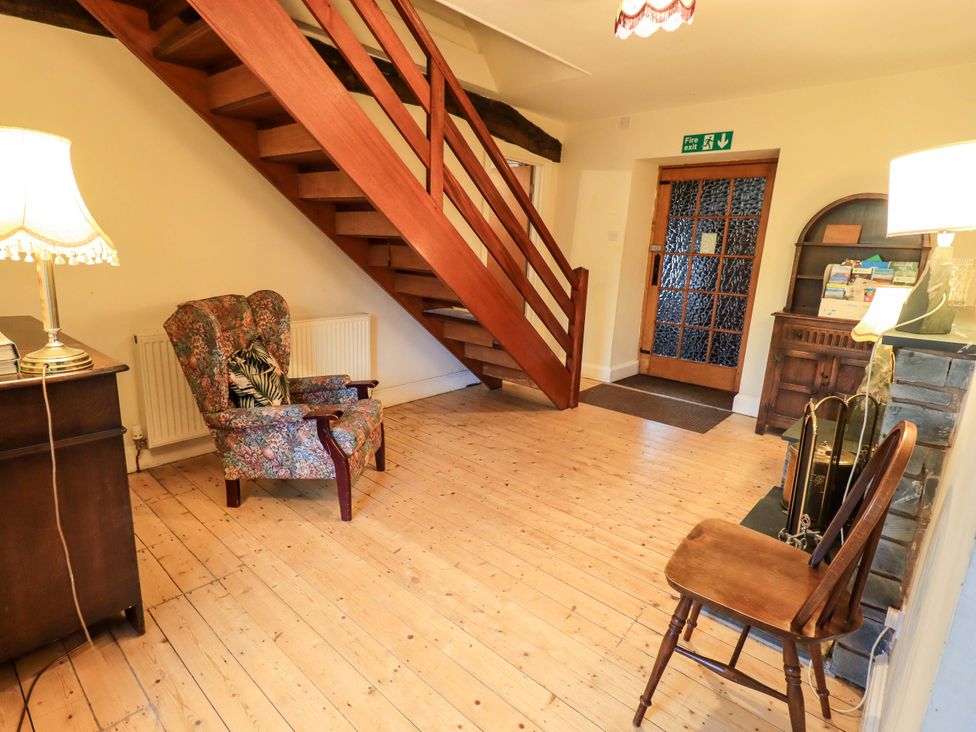 An entryway with a staircase and furniture at Ghyll Bank House in Staveley near Windermere