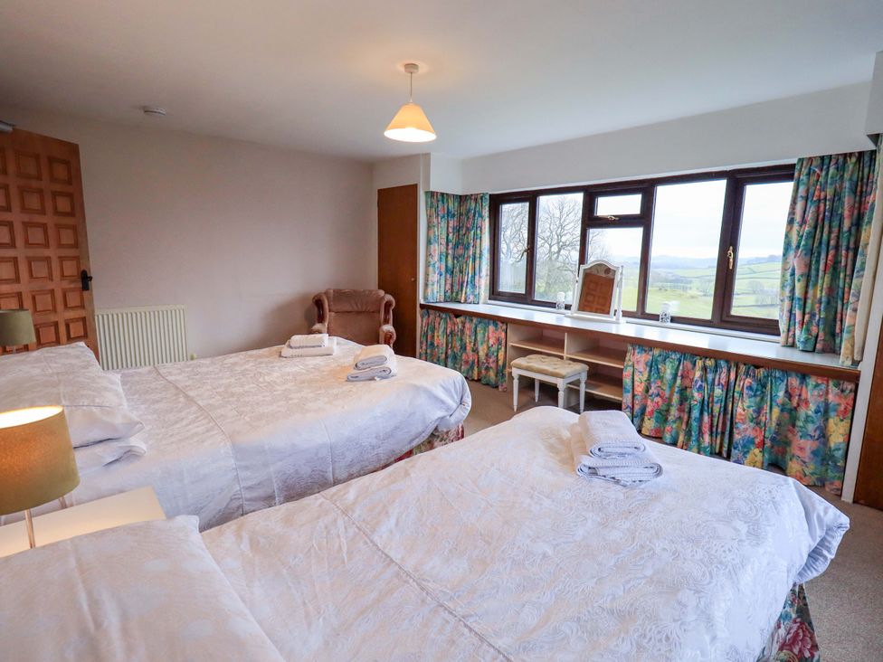 A bedroom with two beds and a window at Ghyll Bank House in Staveley near Windermere