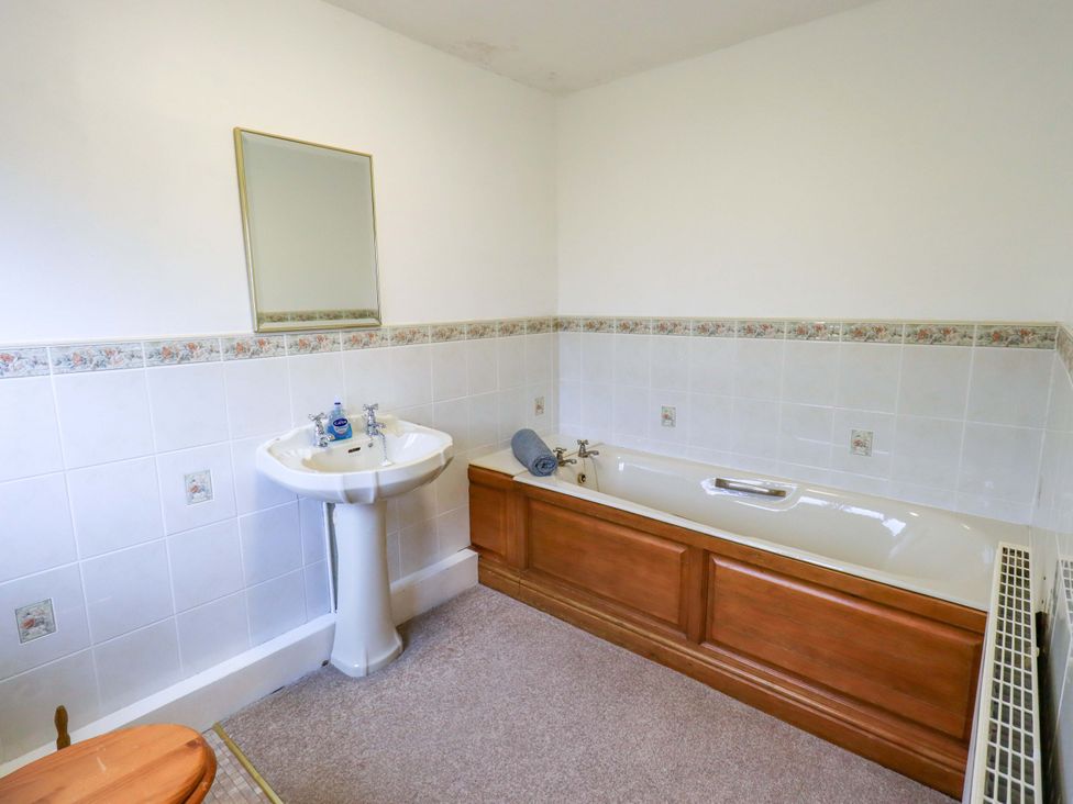 A bathroom with a sink and bathtub at Ghyll Bank House in Staveley near Windermere