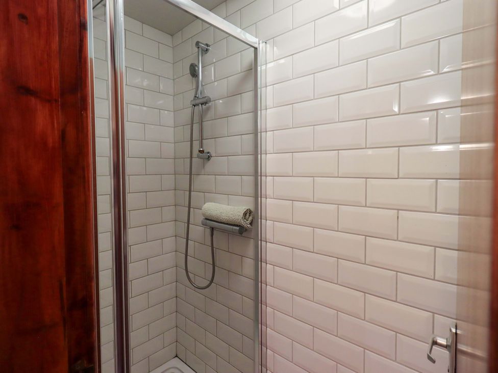 A shower area with wall tiles and towel holder at Ghyll Bank House Staveley near Windermere
