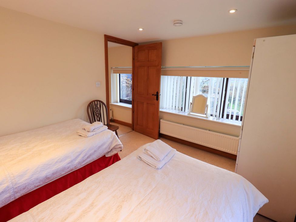 A bedroom with two beds and a window at Ghyll Bank House Staveley near Windermere