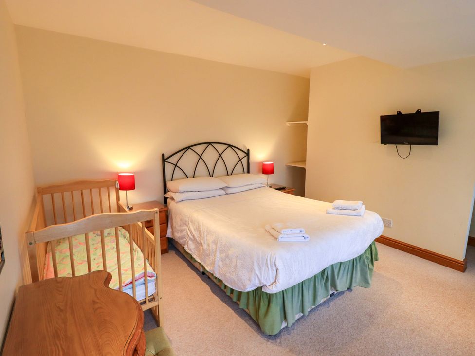 A bedroom with a bed and a cot at Ghyll Bank House Staveley near Windermere