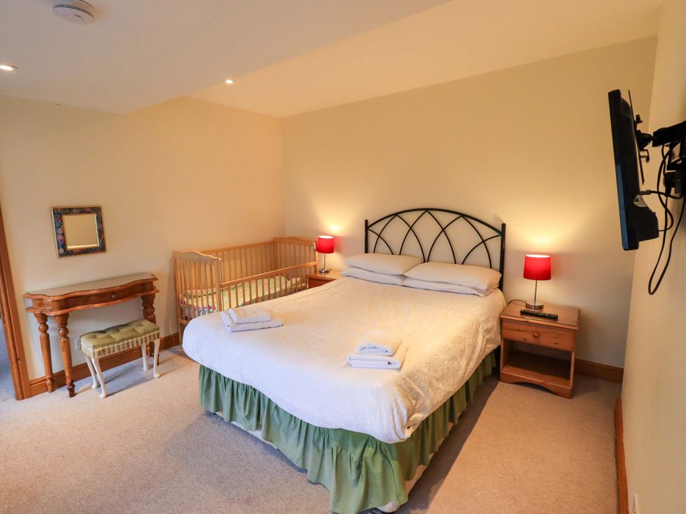 A bedroom with a bed and crib at Ghyll Bank House Staveley near Windermere