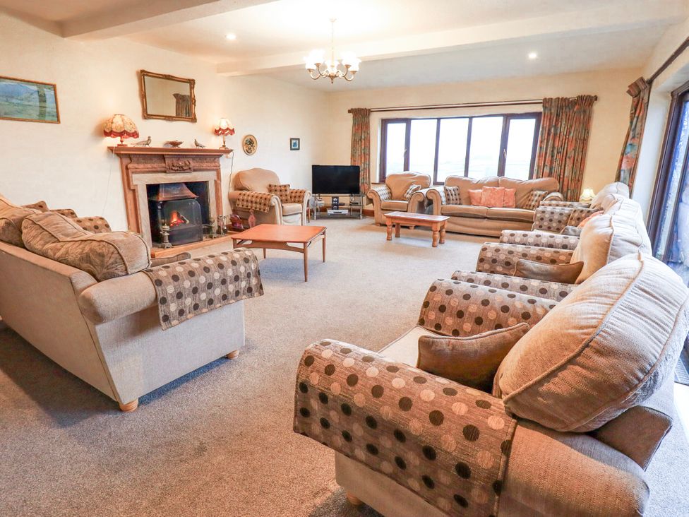 A living room with sofas and a fireplace at Ghyll Bank House in Staveley near Windermere