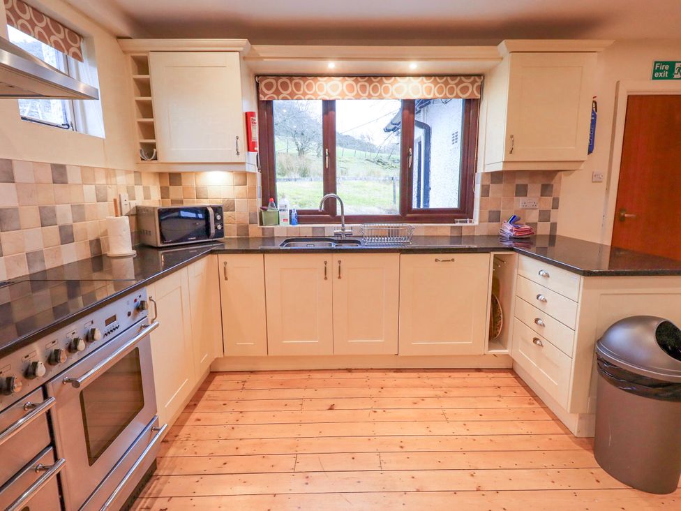 A kitchen with cabinets and appliances at Ghyll Bank House in Staveley near Windermere