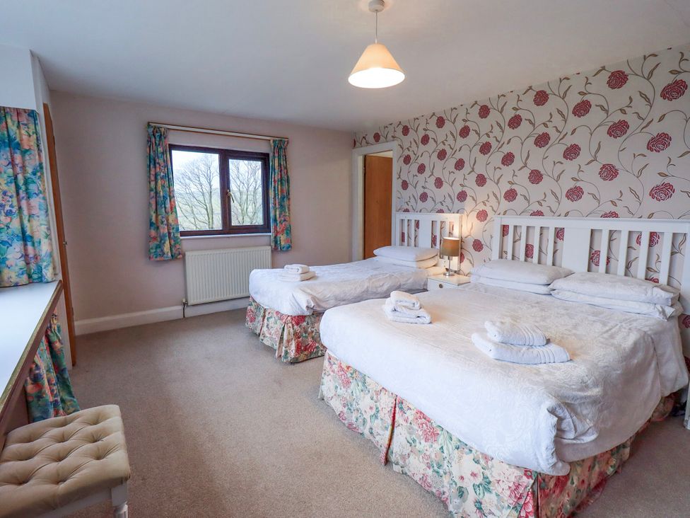 A bedroom with two beds and a window at Ghyll Bank House Staveley near Windermere