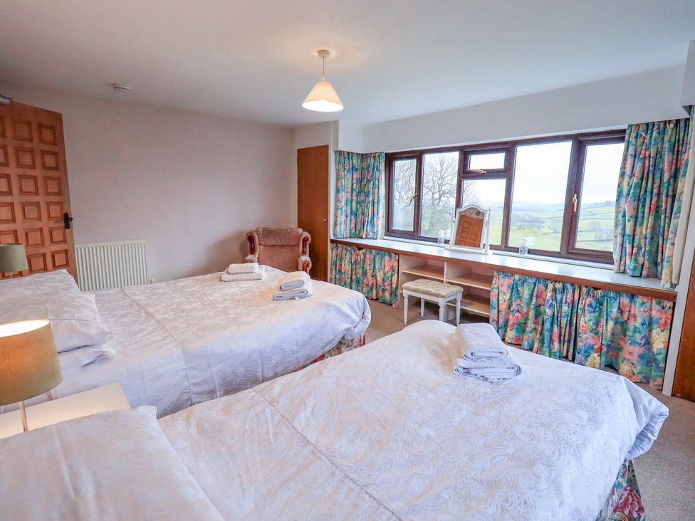 A bedroom with two beds and a dressing table at Ghyll Bank House Staveley near Windermere
