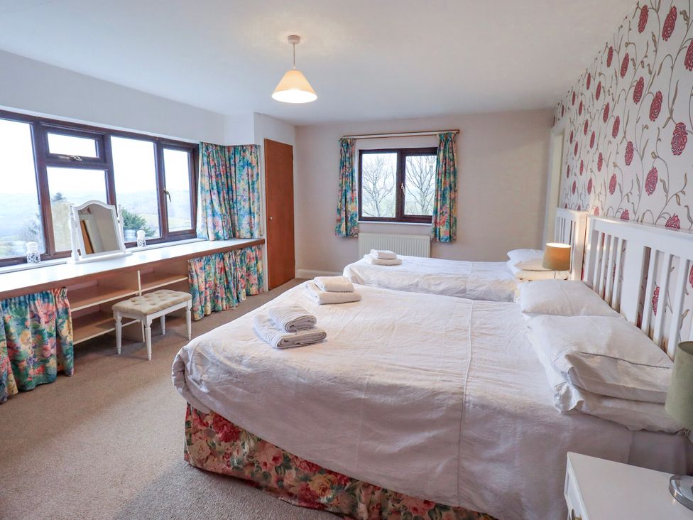 A bedroom with two beds and a dressing table at Ghyll Bank House Staveley near Windermere