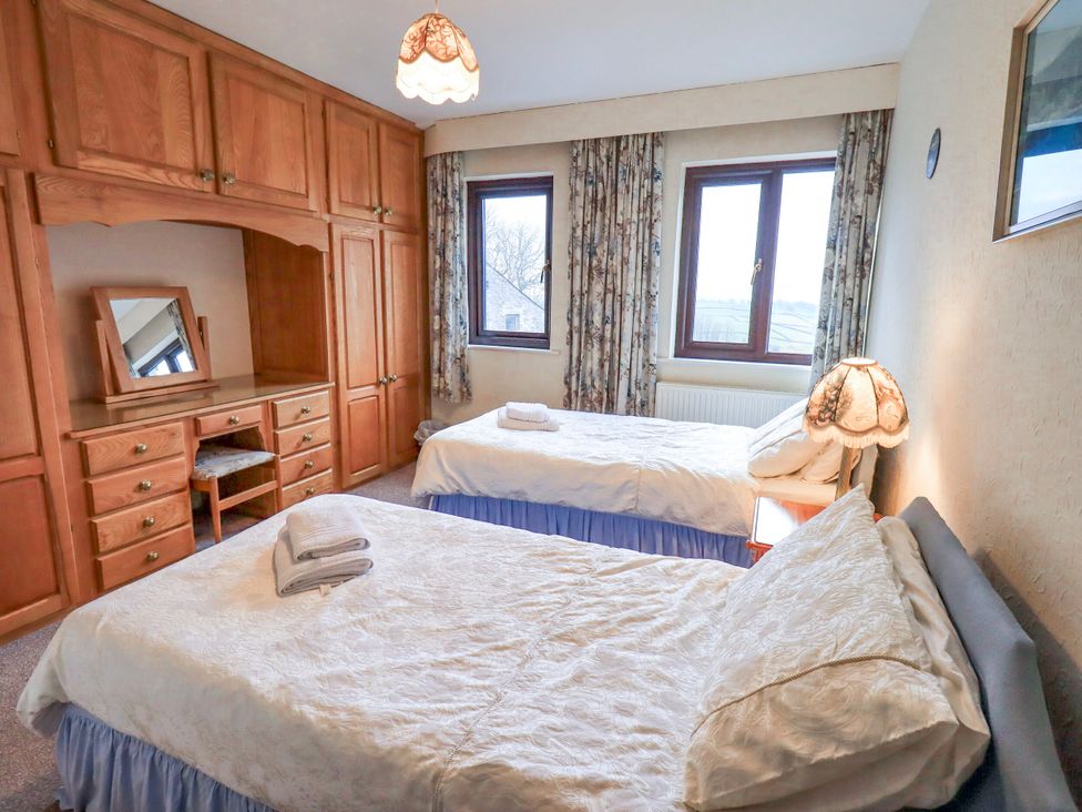 A bedroom with two beds and a desk at Ghyll Bank House Staveley near Windermere